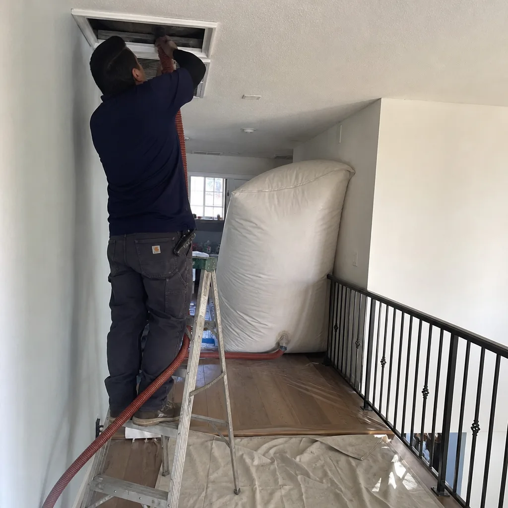 Professional technician performing residential air duct cleaning service